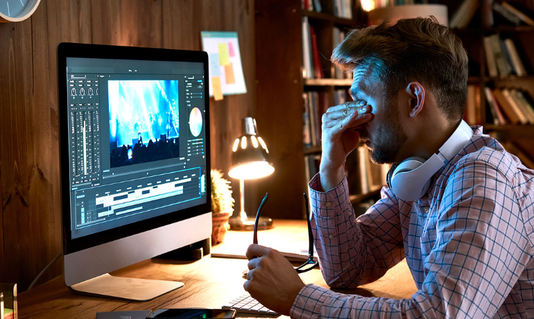 Man working on a computer, experiencing Computer Vision Syndrome