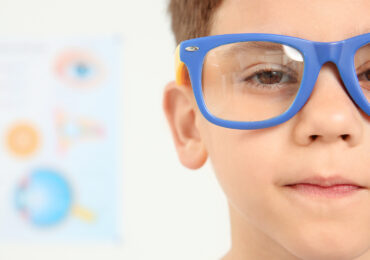 Cute little boy with glasses visiting ophthalmologist img